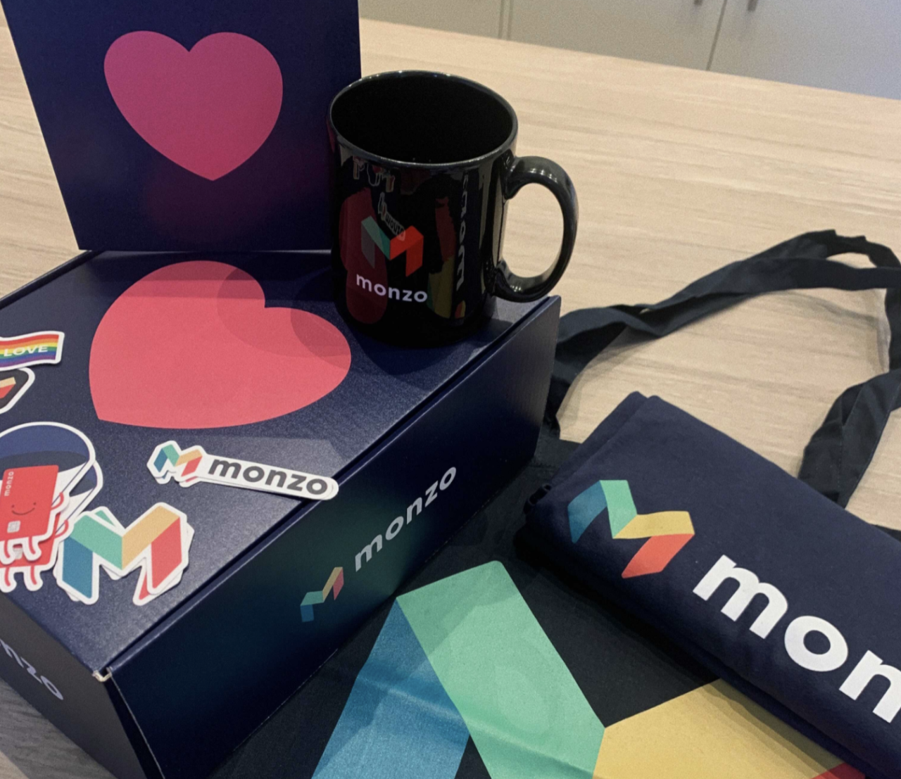 Monzo swag box for new joiners including a mug, t-shirt, and lots of stickers!