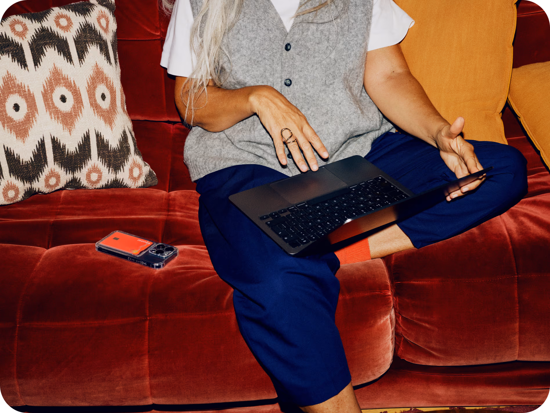 A person sits on a sofa looking at their laptop