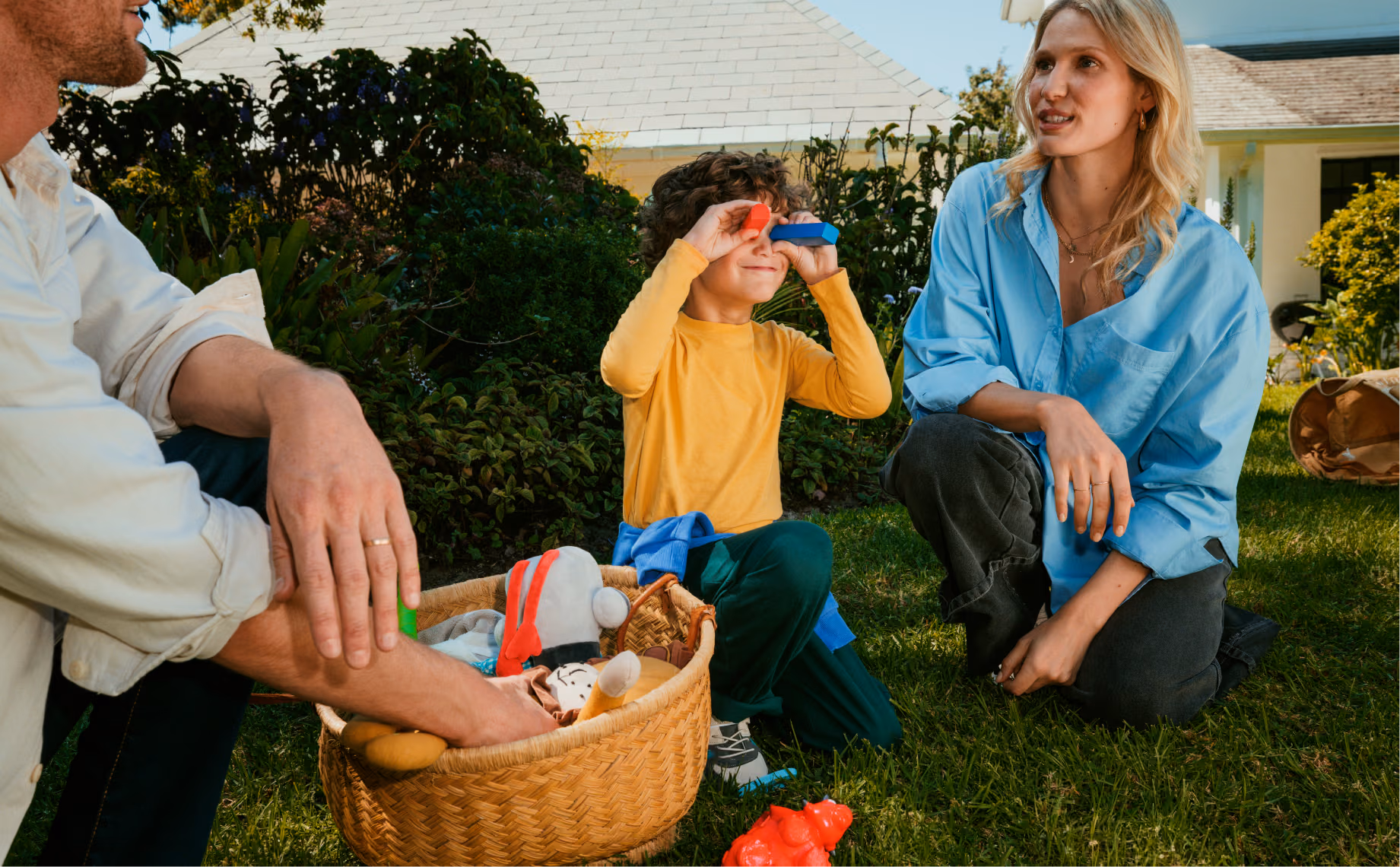 A family of a mother, father and son playing in the garden.