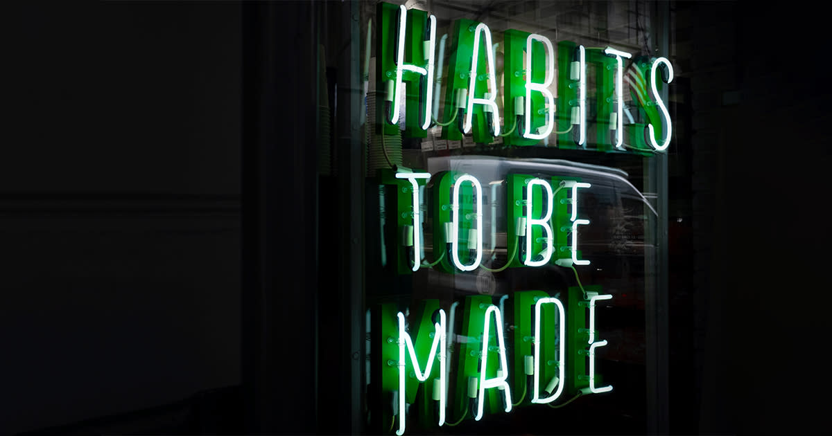 A green neon sign that says "Habits to be made"