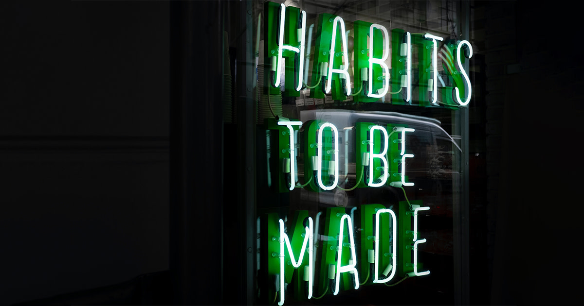 A green neon sign that says "Habits to be made"