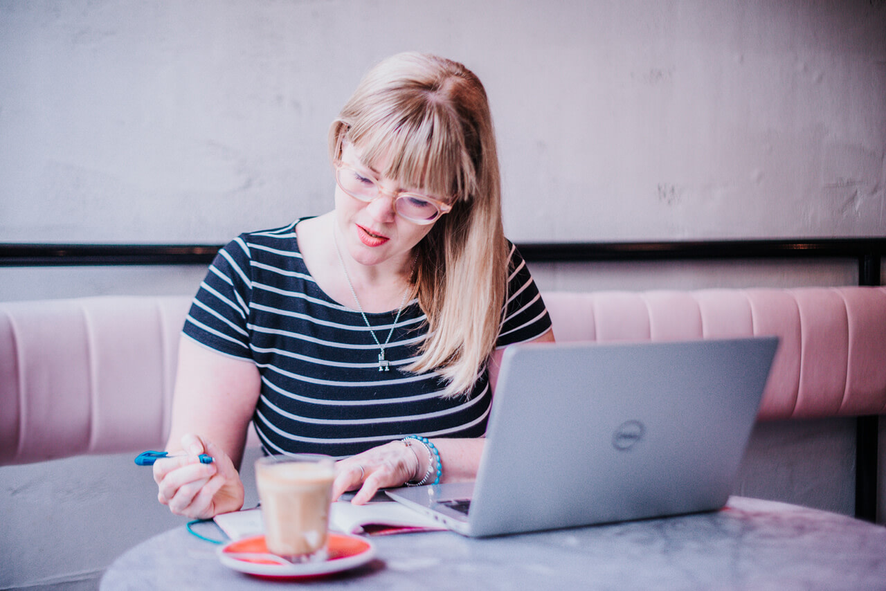 image of a woman with a laptop and a coffee