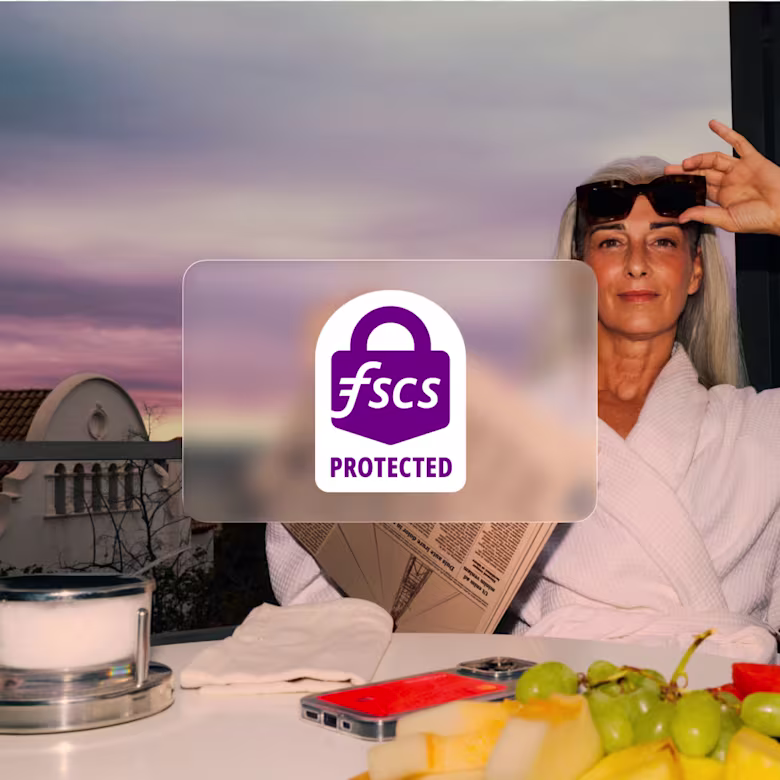 A woman relaxes outdoors in a white robe next to a plate of fruit, with a prominent purple Financial Services Compensation Scheme (FSCS) Protected badge overlaying the foreground.