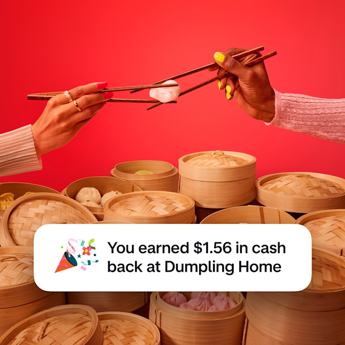 Two arms holding chopsticks with each pair of chopsticks holding onto the same dumpling against a red background. There is a celebration emoji with text saying You earned $1.56 in cash back at Dumpling Home.