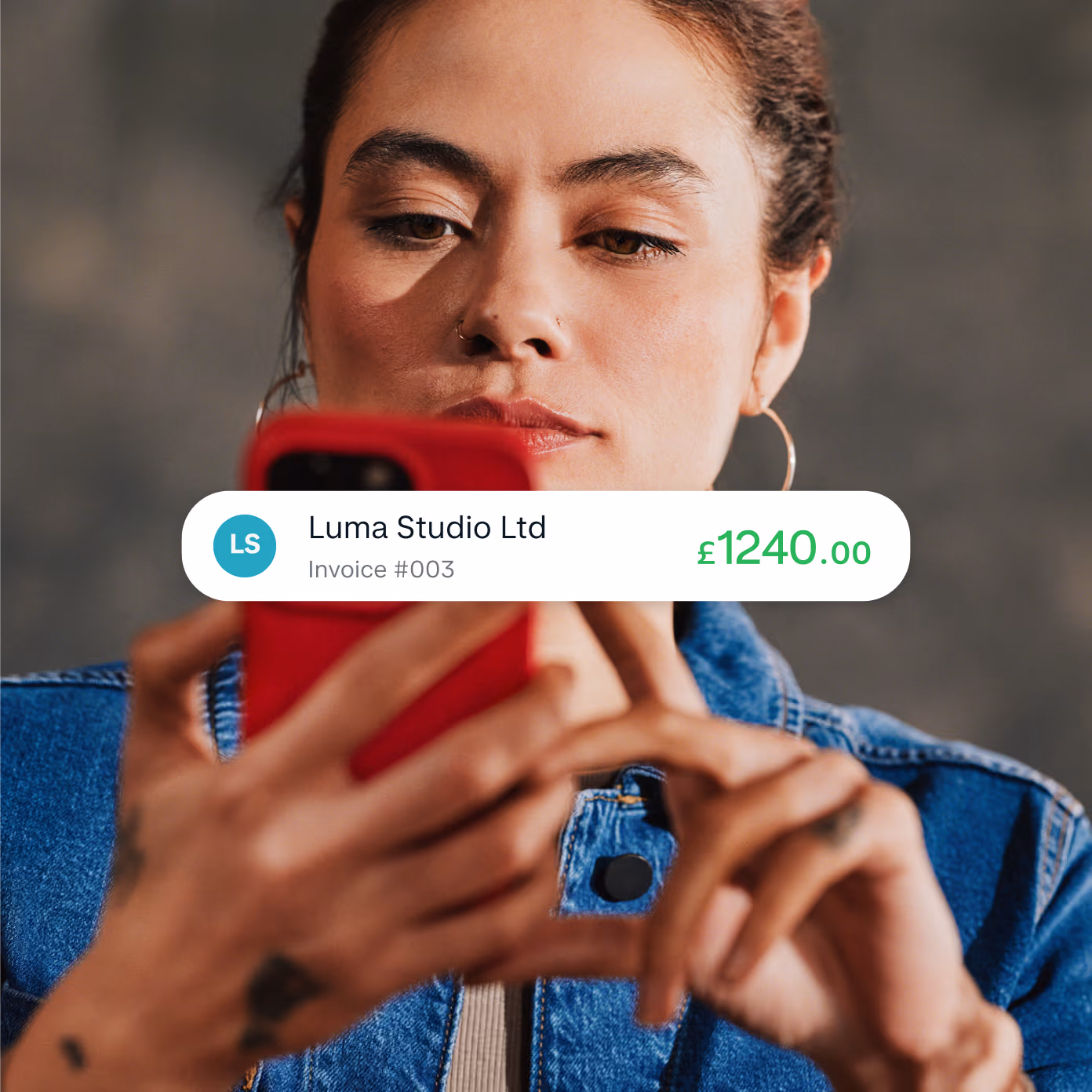 A Monzo Business owner looking at her phone, with an app screenshot overlaid showing a payment following a customer's bank transfer