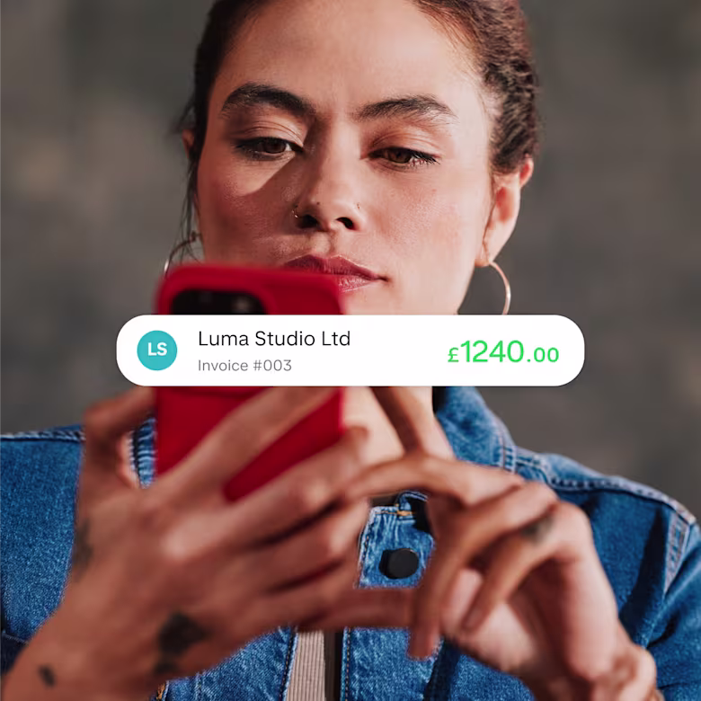 A Monzo Business owner looking at her phone, with an app screenshot overlaid showing a payment following a customer's bank transfer