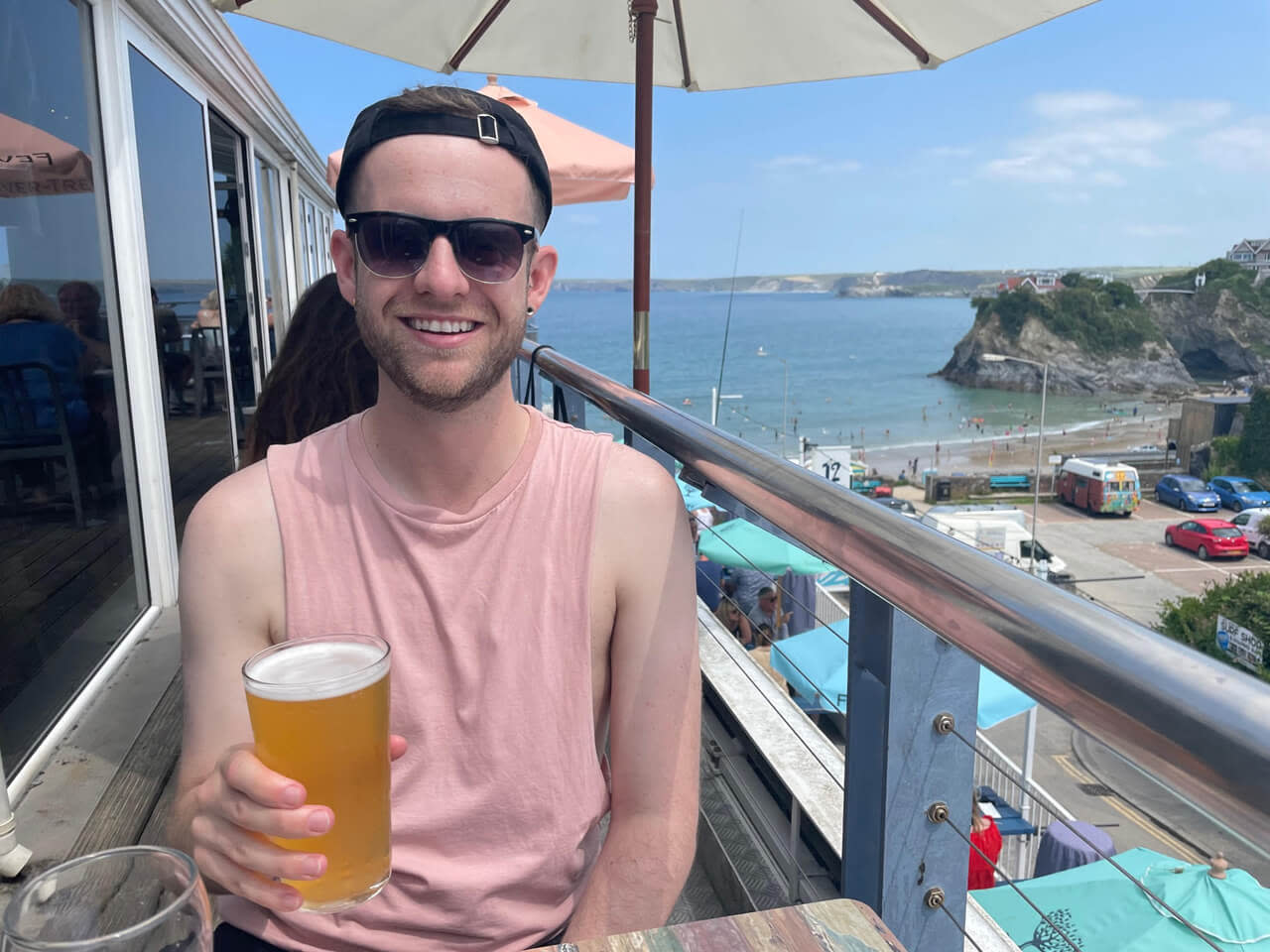 Man sitting on a sunny balcony with a pint