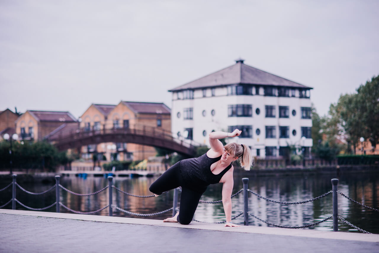 woman doing yoga by a canal