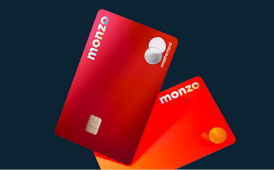 Two Monzo Perks and Monzo Max cards angled against a dark-navy background.