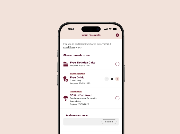 A smartphone screen displaying the "Your rewards" section of a mobile app. The screen lists three available rewards: "Free Birthday Cake" (expires 29/05/2025), "Free Drink" with 1 remaining (expires 29/05/2025), and "30% off all food" with 1 remaining (expires 29/05/2025). Each reward has a circular selection option beside it. At the bottom, there is a field to add a reward code with a "Submit" button.