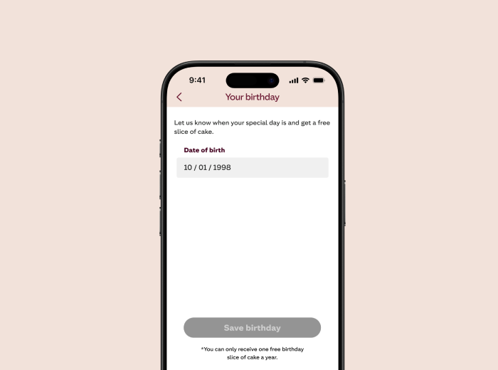 A smartphone screen displaying the "Your birthday" section of a mobile app. The screen invites the user to enter their birth date to receive a free slice of cake. The date of birth field is filled with "10/01/1998." Below it is a greyed-out "Save birthday" button, and a note at the bottom reads: "*You can only receive one free birthday slice of cake a year