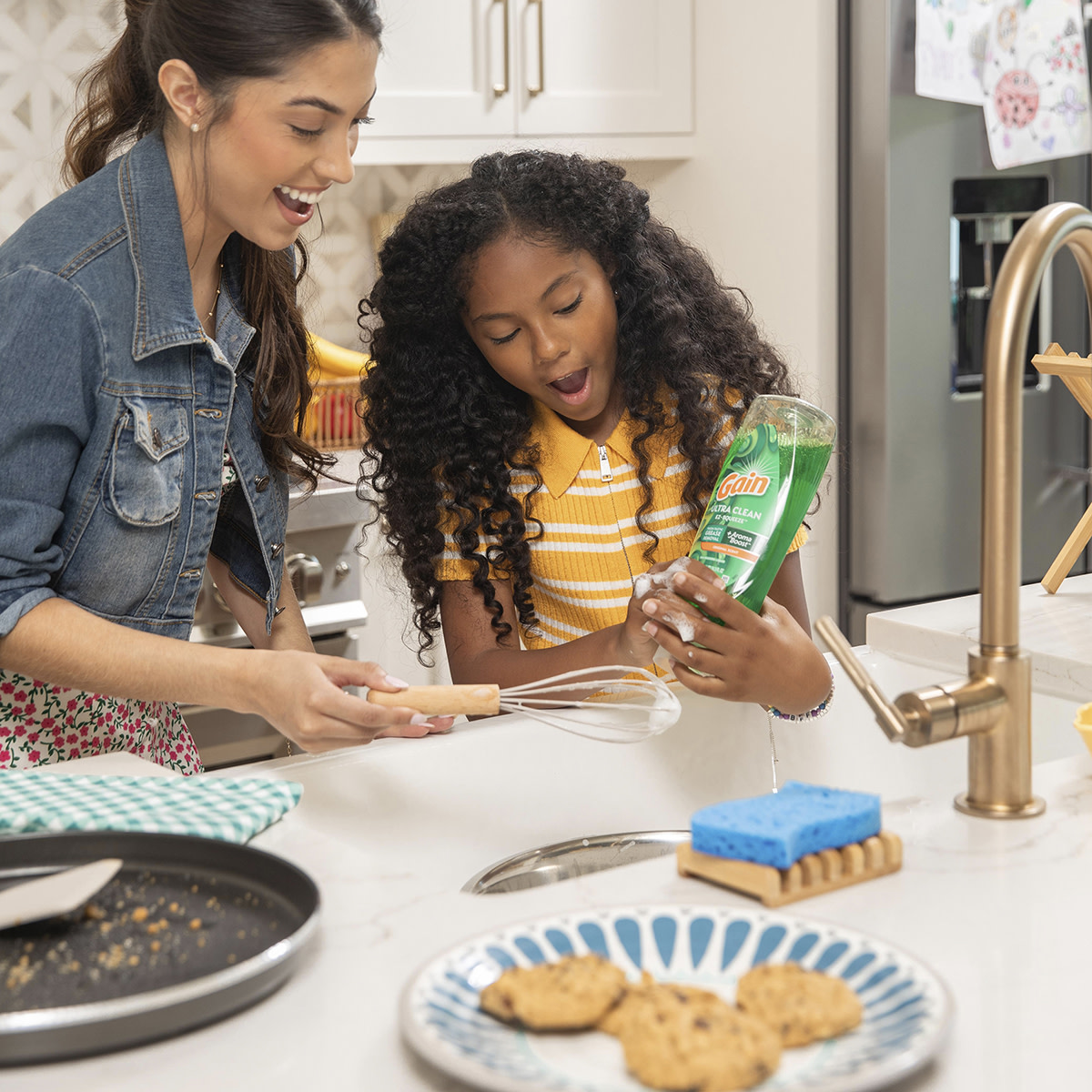 Mother and daughter wash the dishes together with Gain