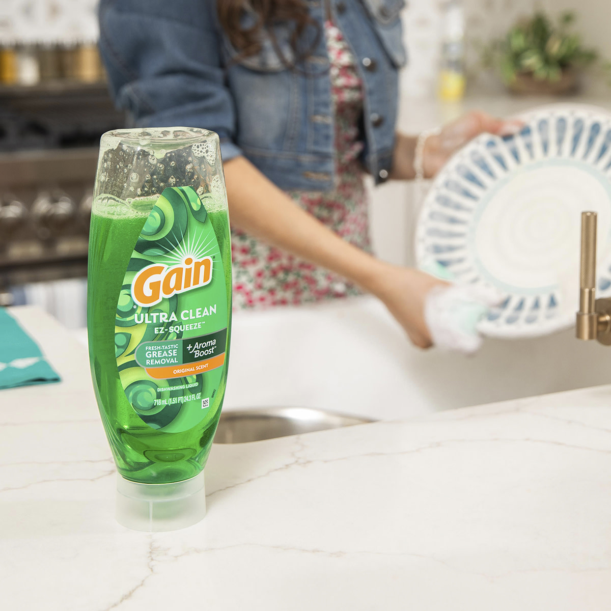 Gain Ultra Clean Ex-Squeeze in the kitchen while person is washing the dishes in background
