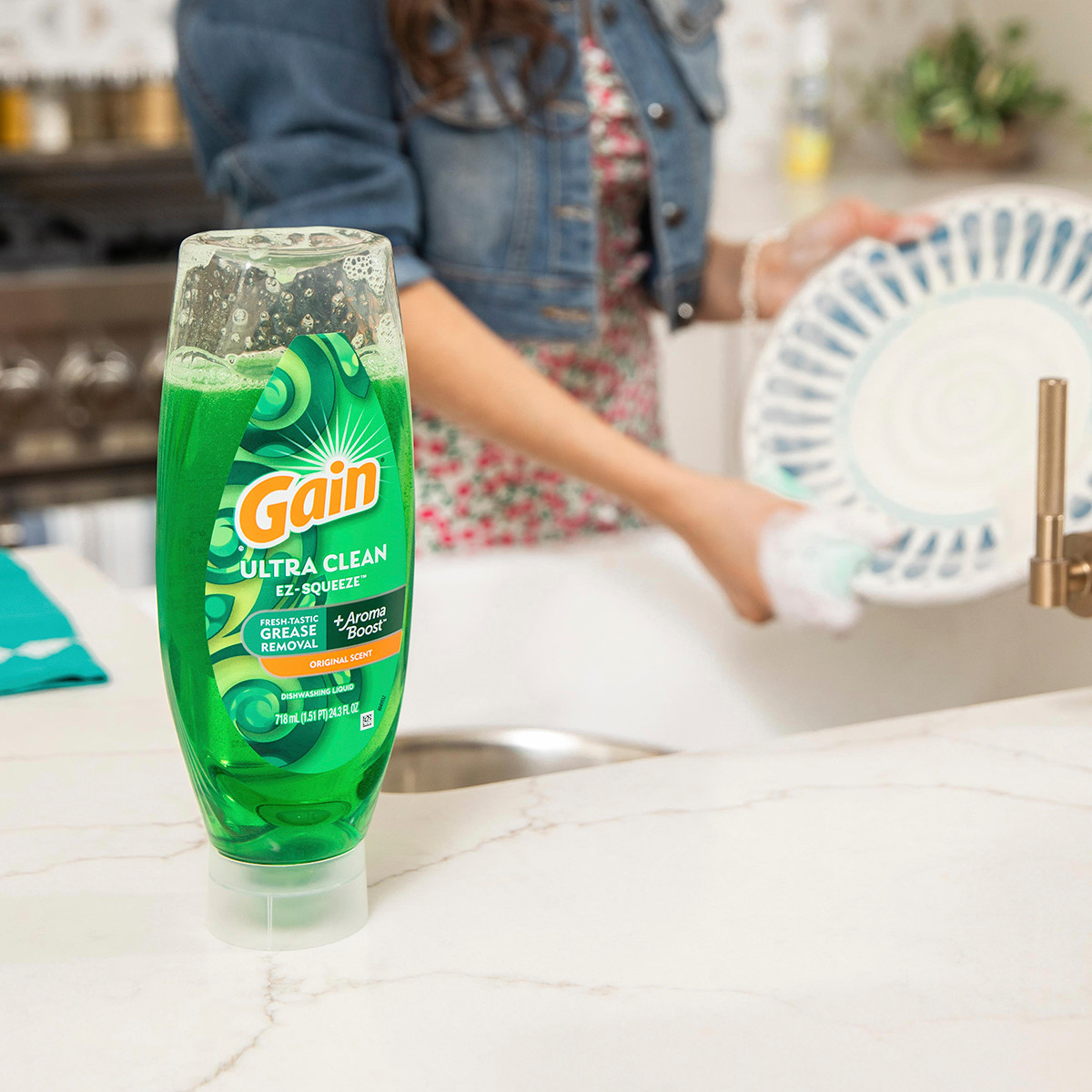 Gain Ultra Clean Ex-Squeeze in the kitchen while person is washing the dishes in background