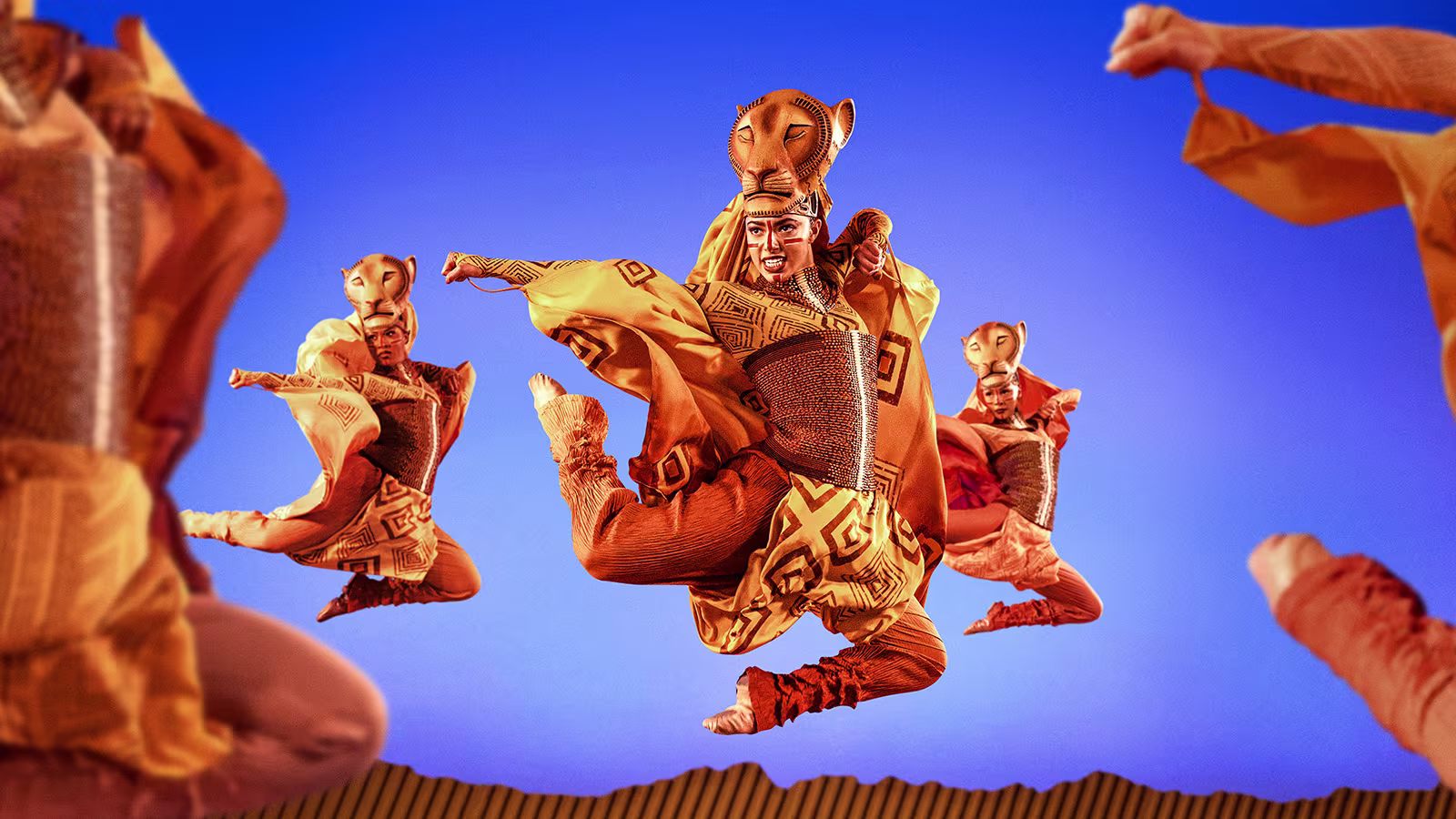 Disneys Der König der Löwen Showbild der Cast tanzend vor blauem Hintergrund