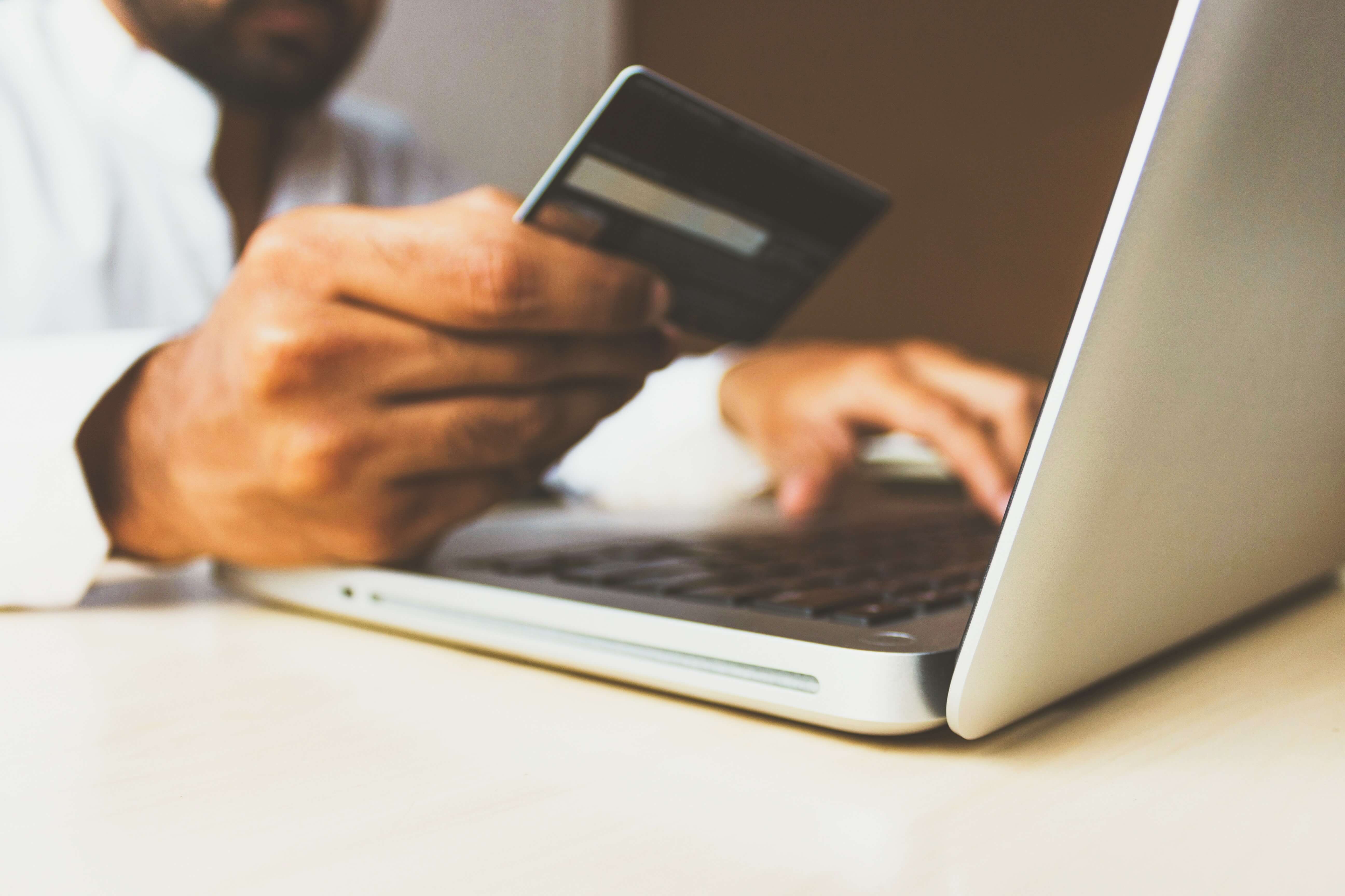 A man making a payment with his credit card on a laptop 