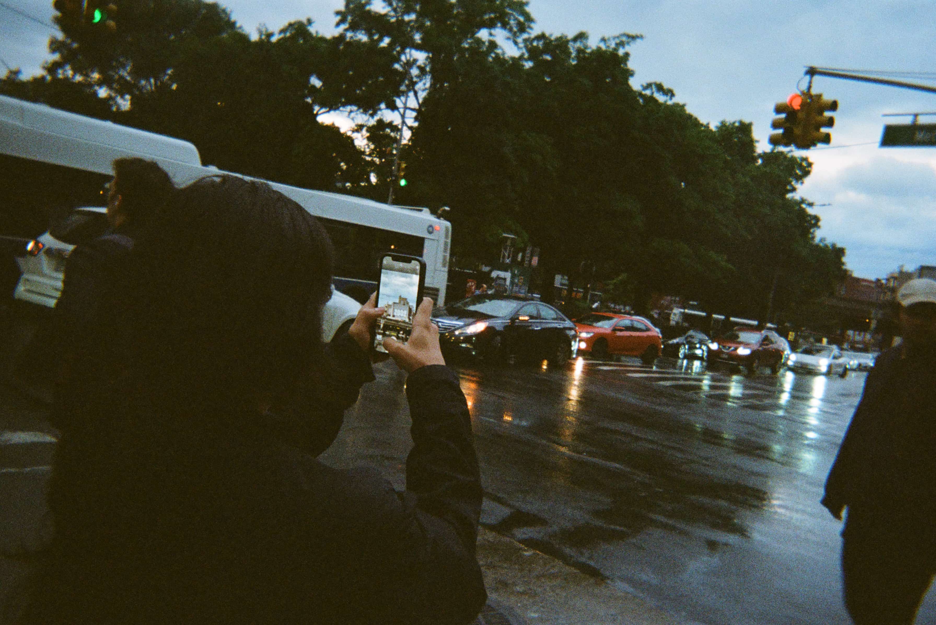 A person taking a picture of a rainy street.