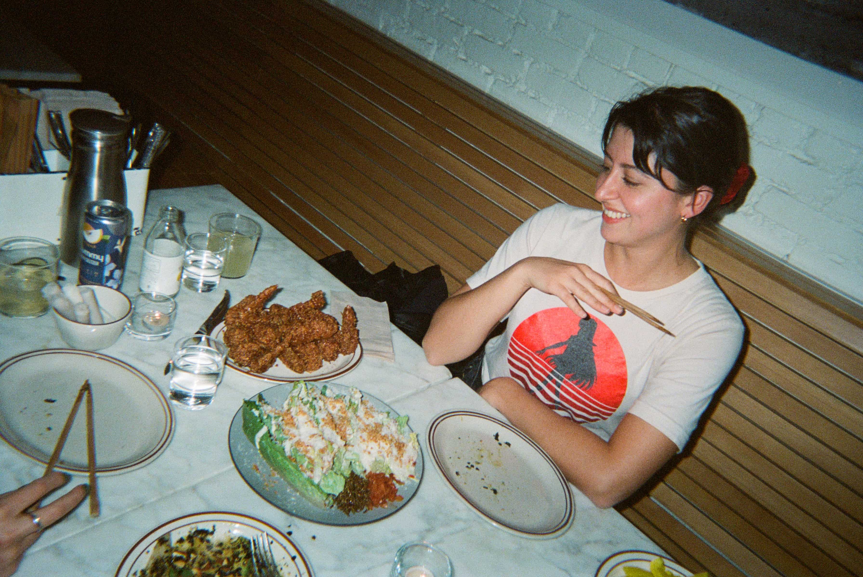 A person sitting at a table with food on it.