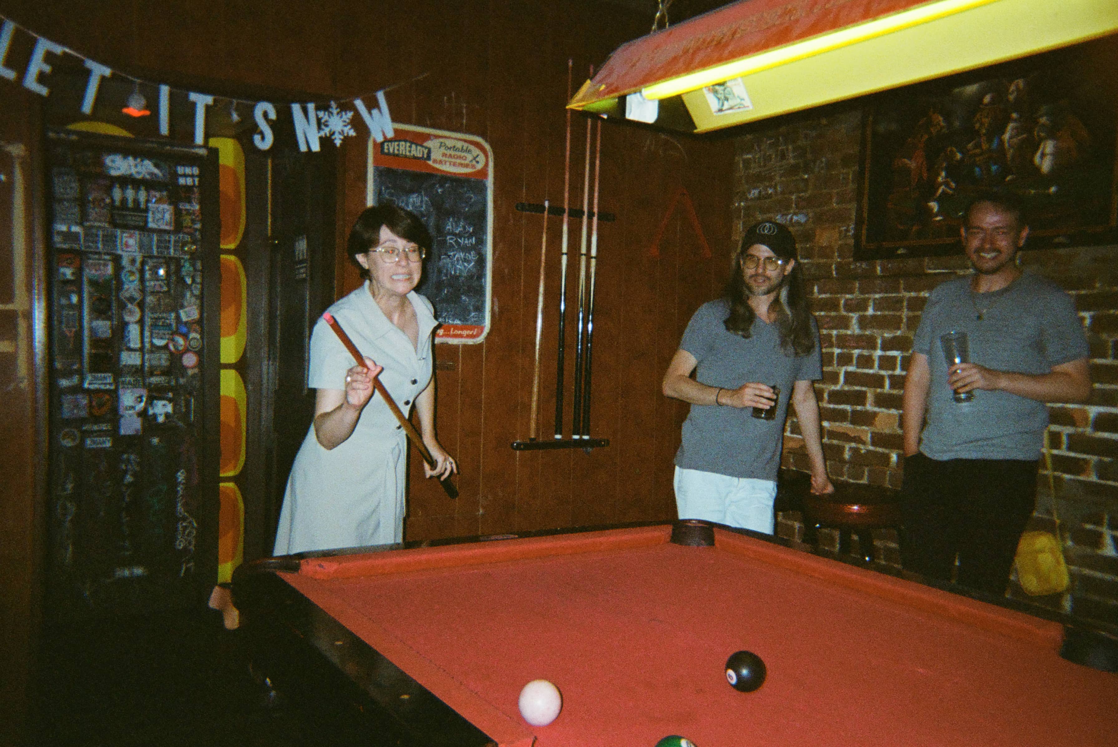 A group of people playing pool.