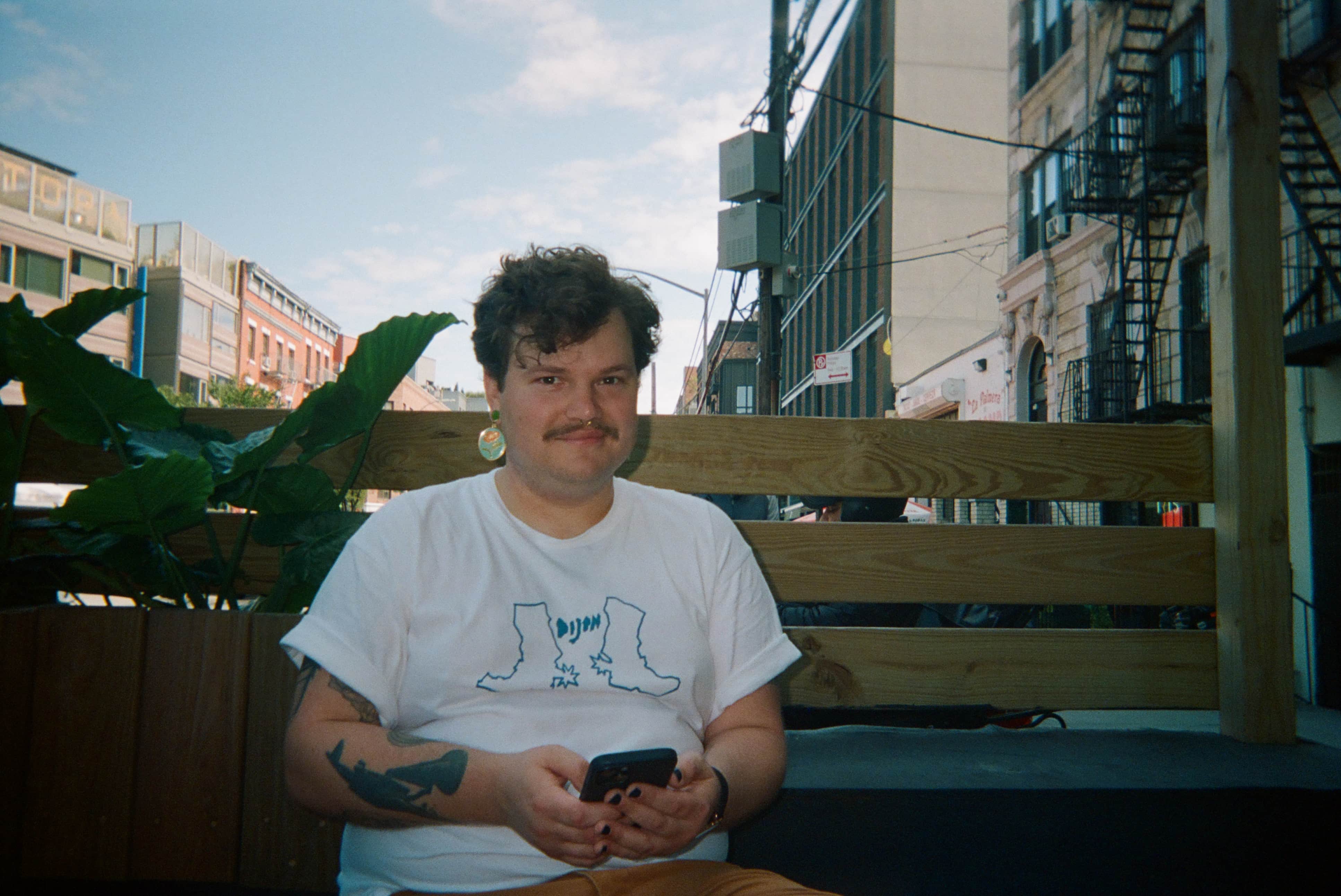 A person sitting on a bench holding a phone.