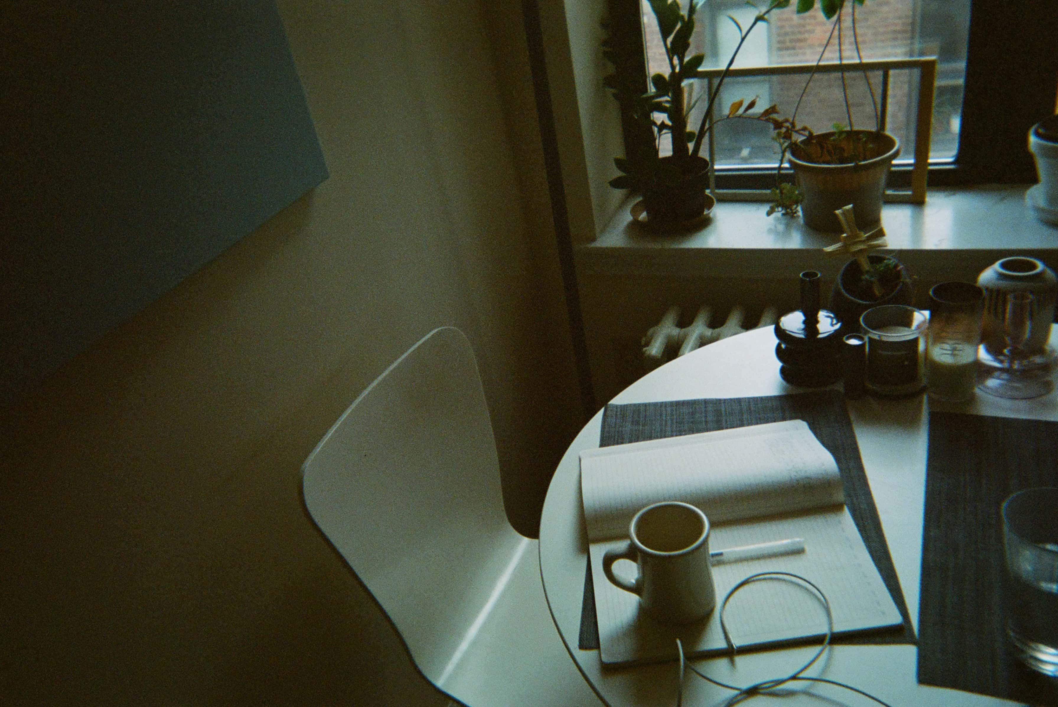 A white chair with a coffee cup on a table.