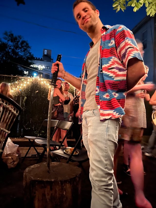 Backyard party with a keg and a sword.