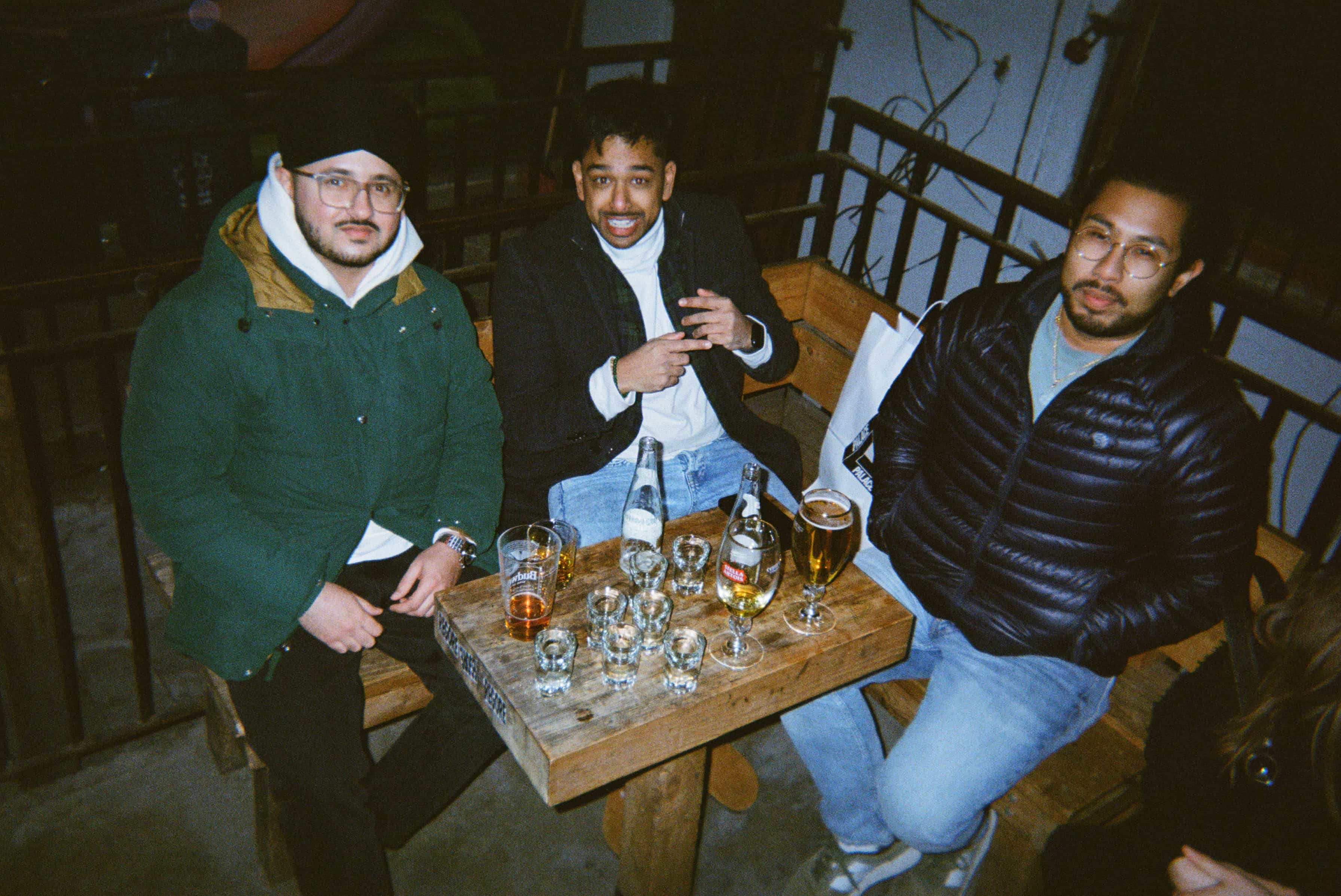 A group of men sitting at a table with glasses of beer.