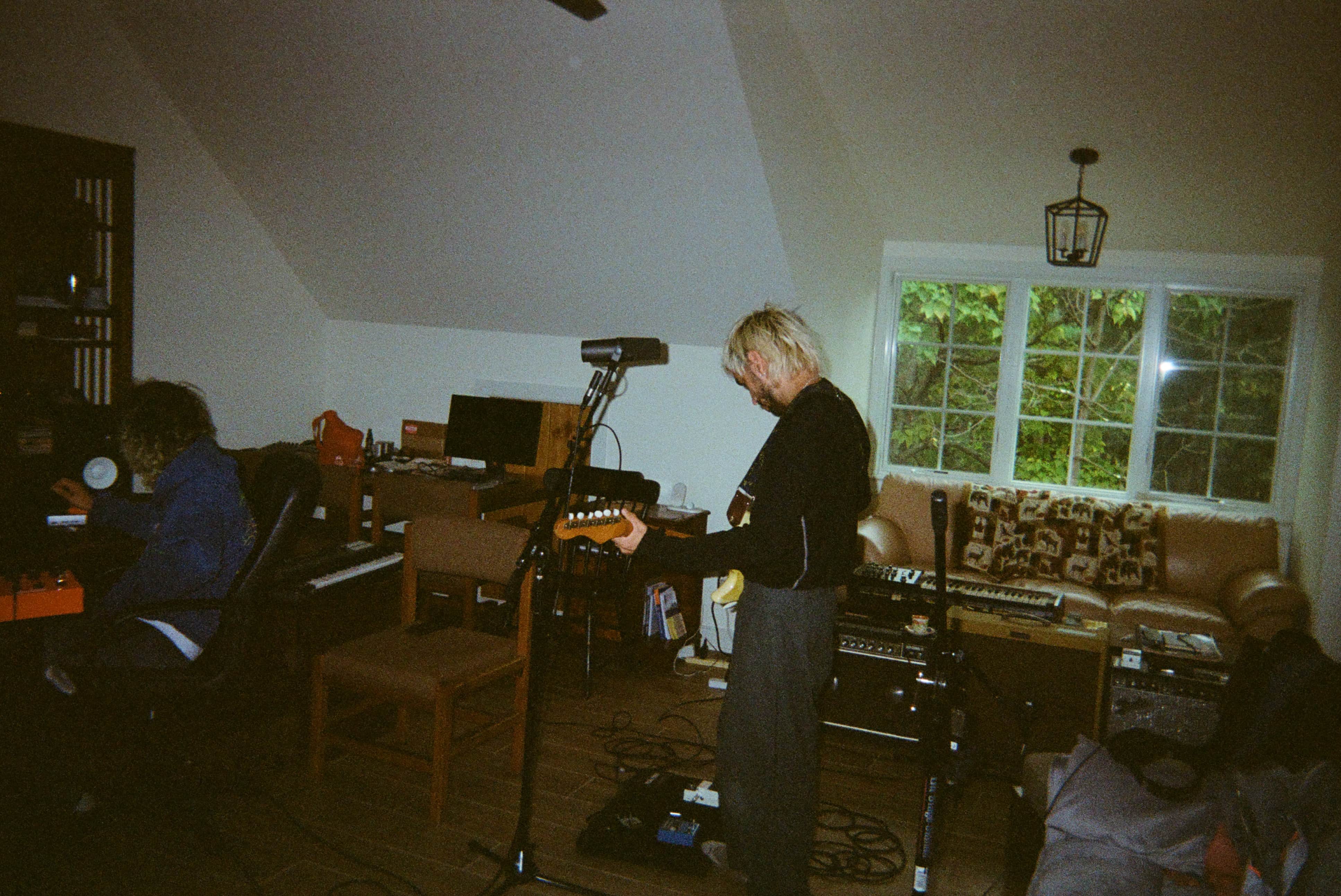 A person playing guitar in a barn recording studio.