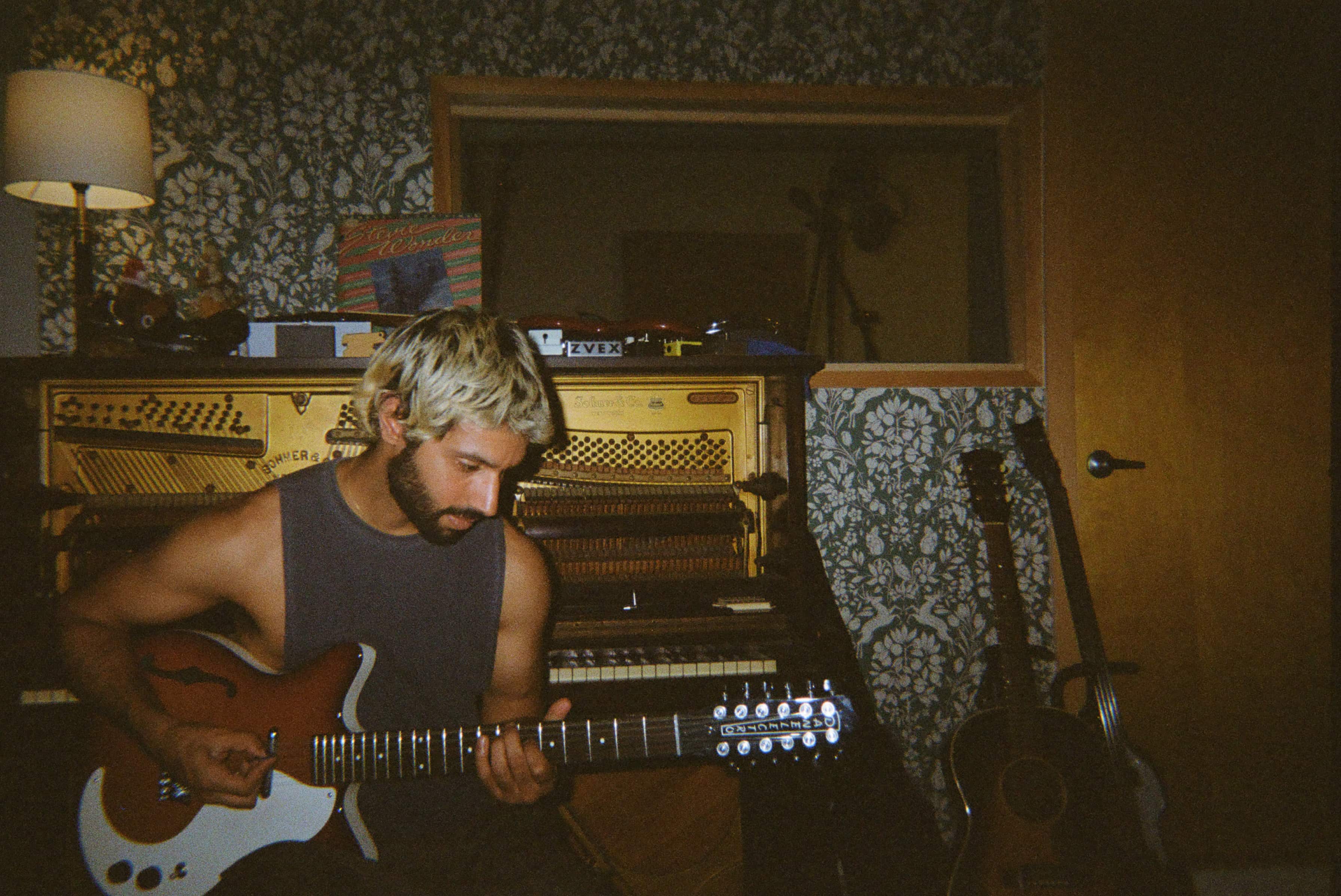 A person playing a guitar in a recording studio.