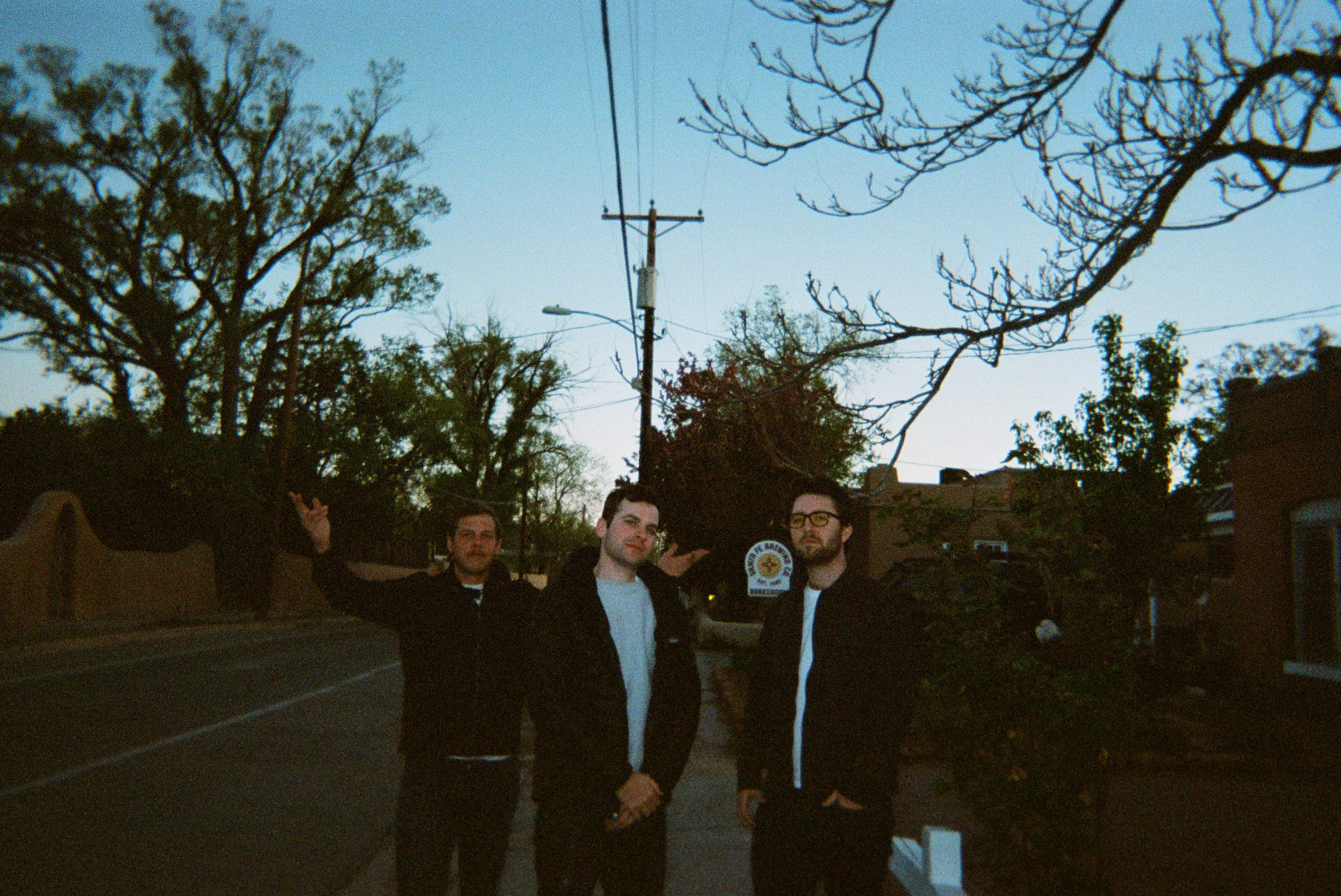 A group of men standing on a street.