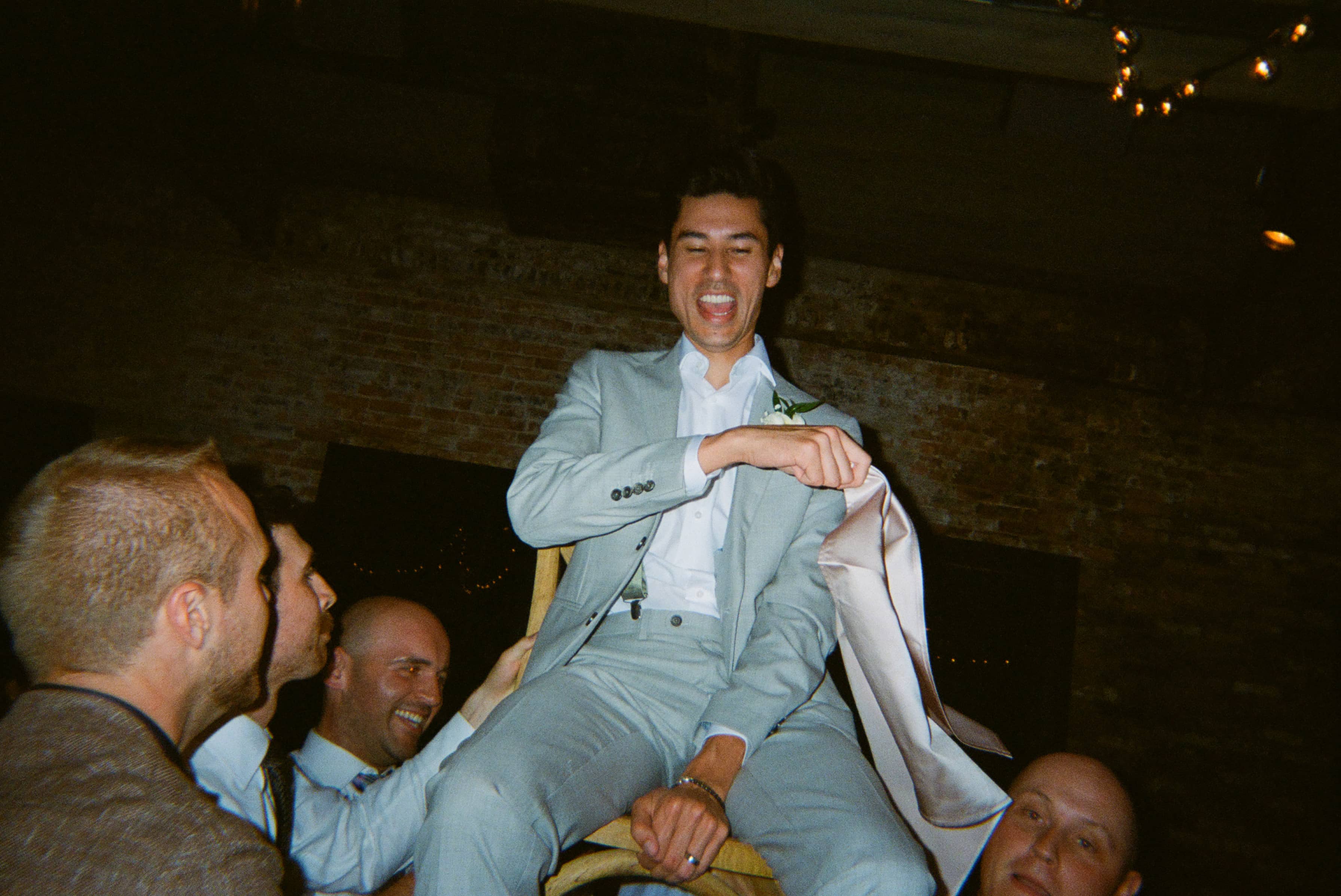 A person in a suit sitting on a chair with his hands on his lap.