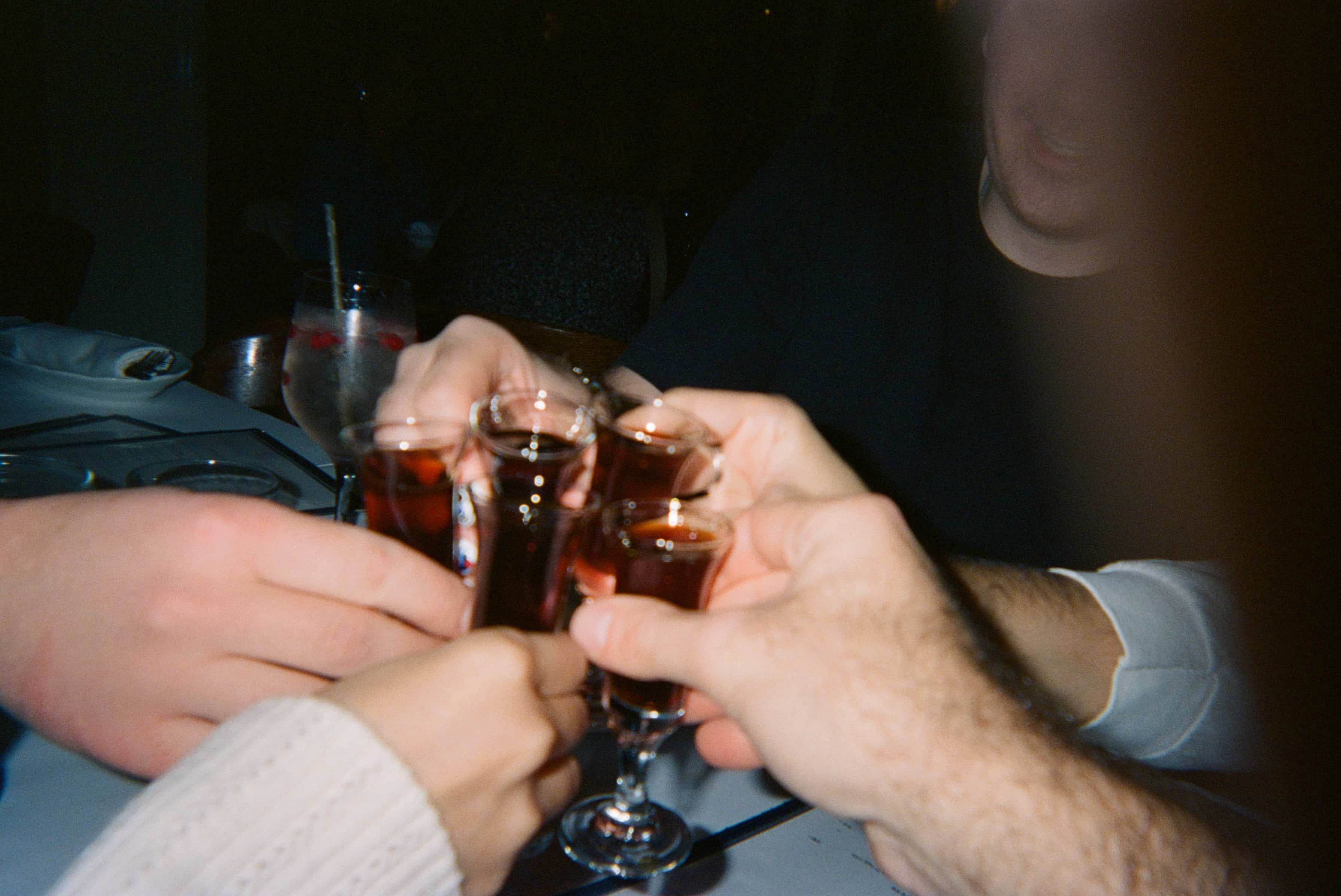 A group of people holding glasses with liquid.