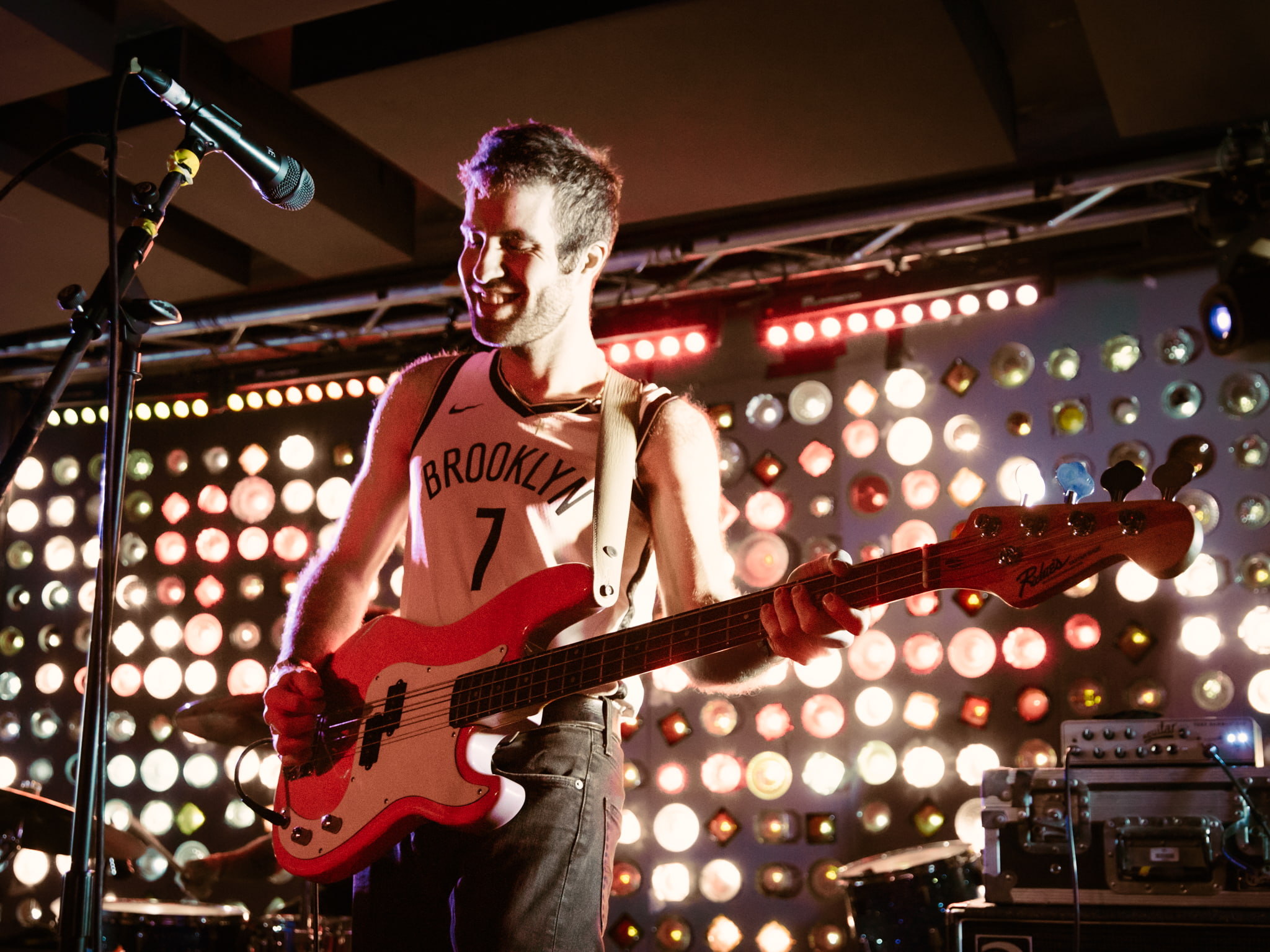 A man playing a bass guitar on a stage.