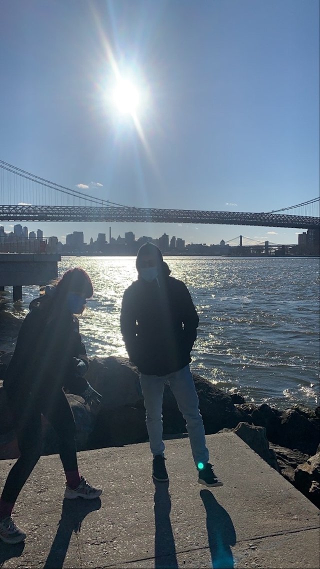 Two friends standing near the East River in Williamsburg Brooklyn.