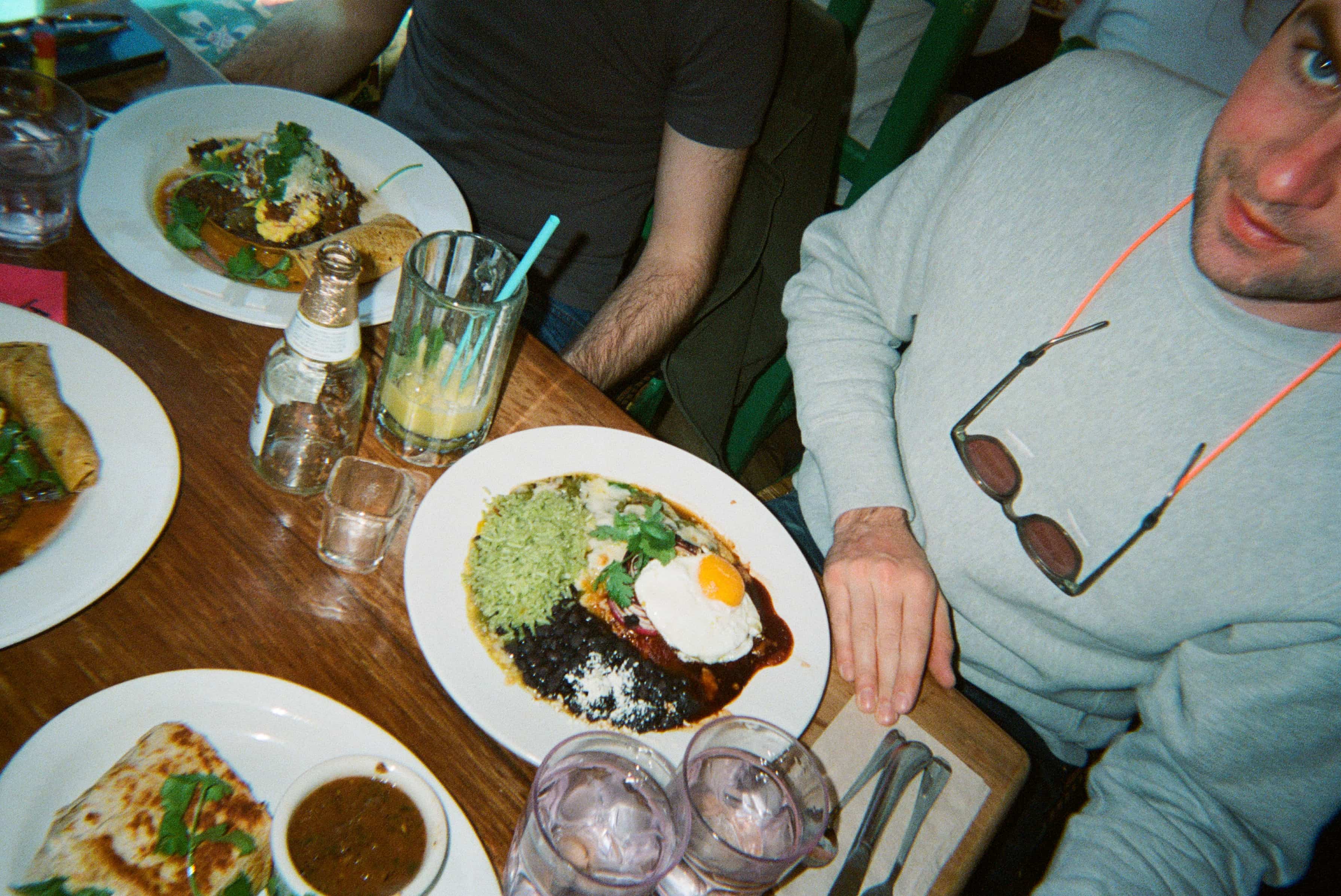A man sitting at a table with plates of food.