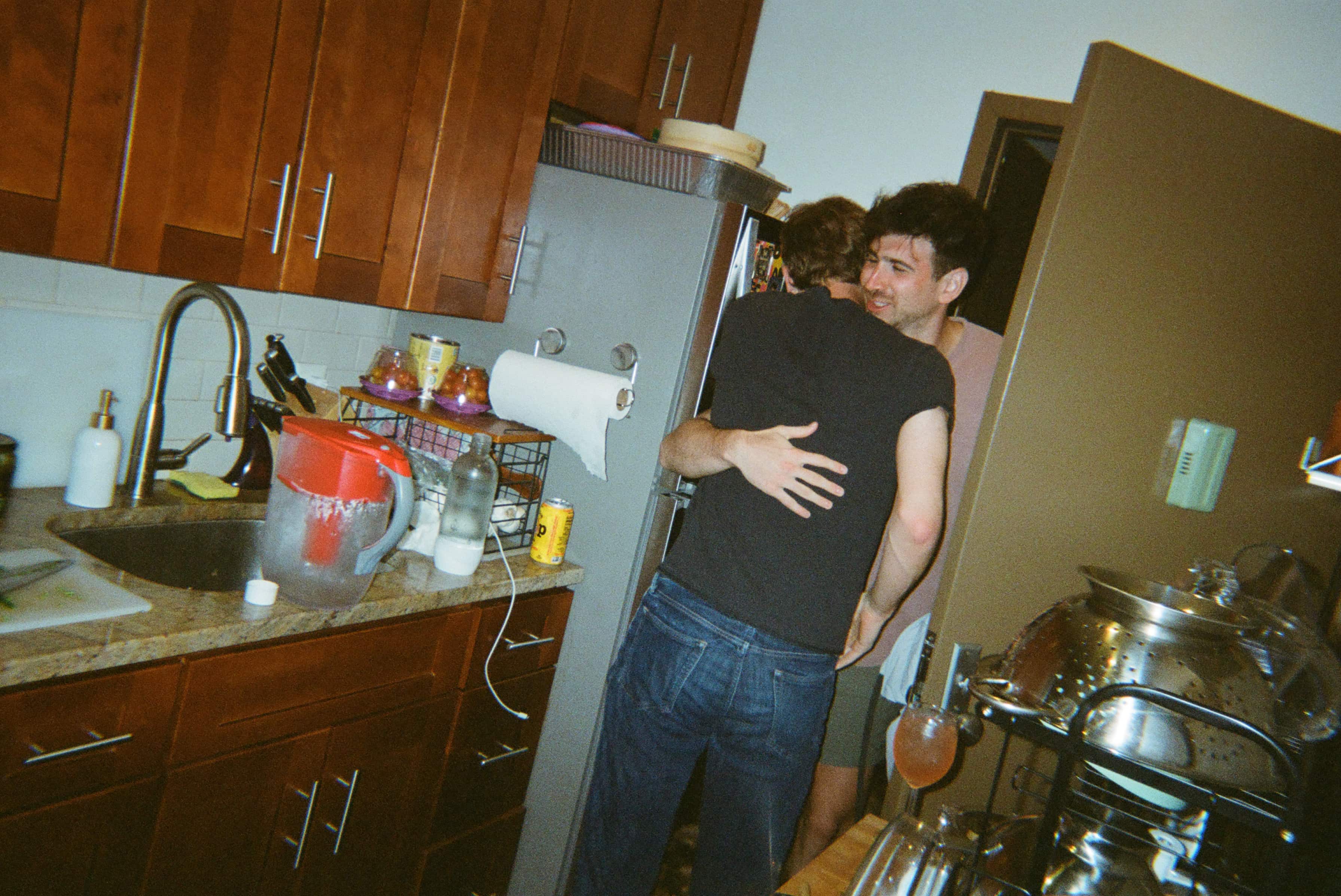 Two people hugging in a kitchen.