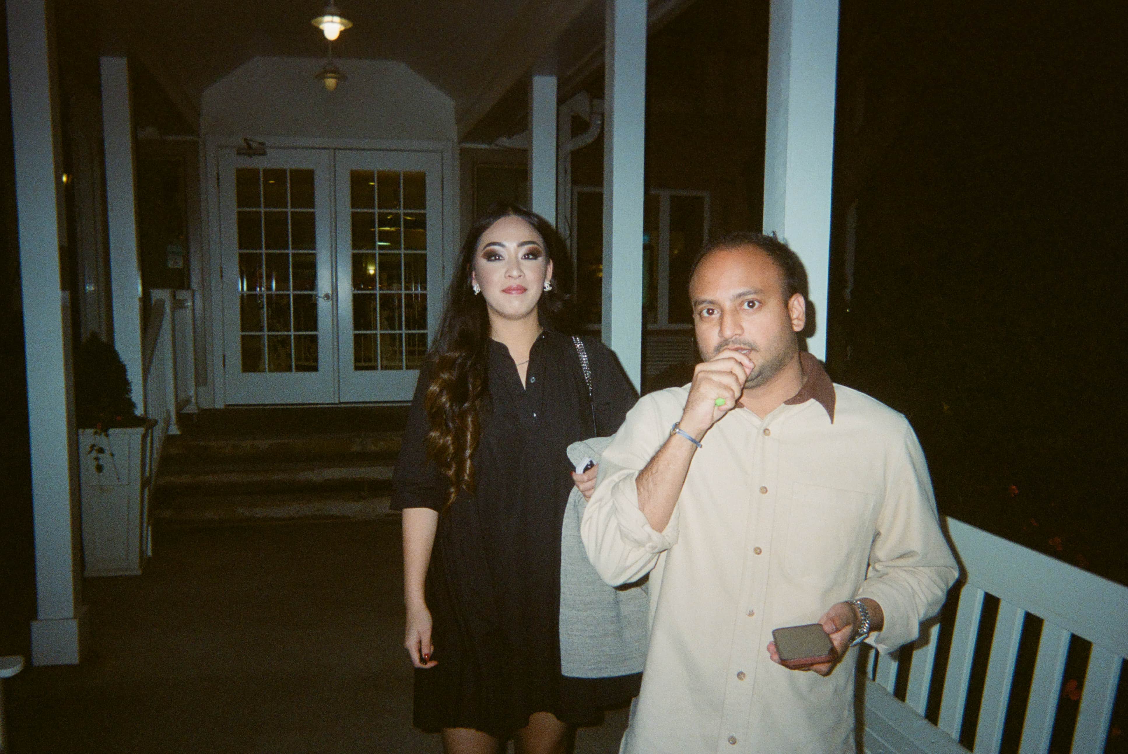 Two people standing outside at night.