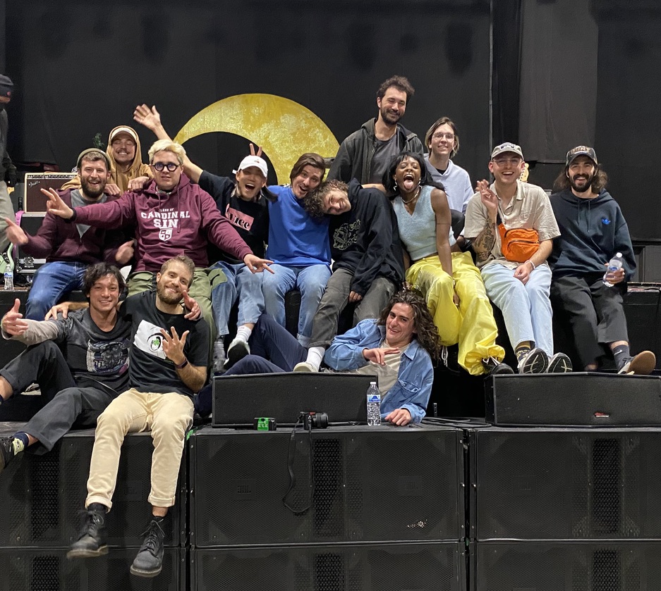 A crowd of people sitting on a stage embracing each other.