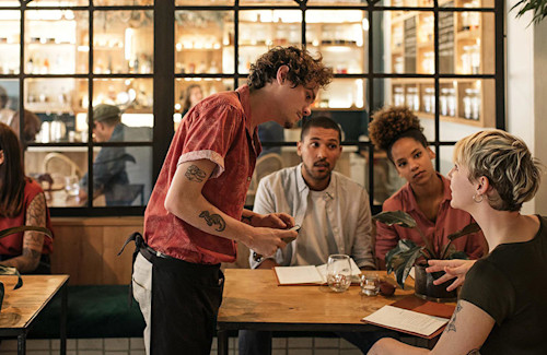 A server talking to guests and learning to upsell.