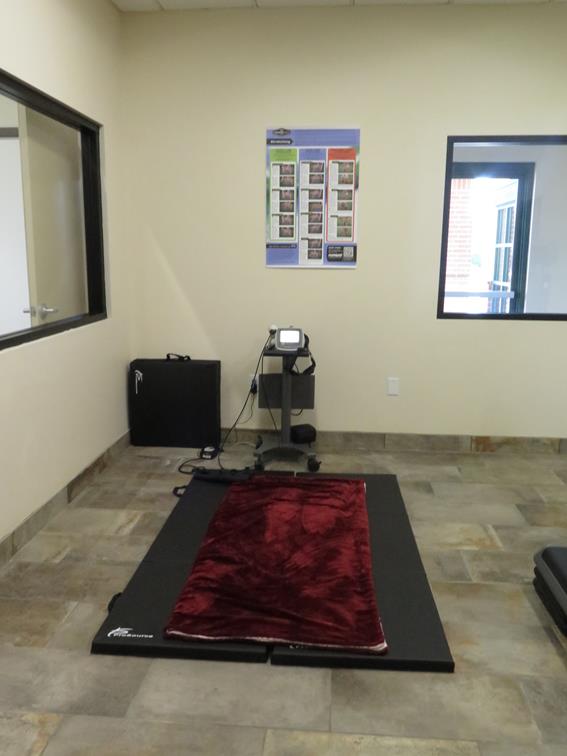 A training mat and a monitoring device for patients displayed in the middle of the room. 