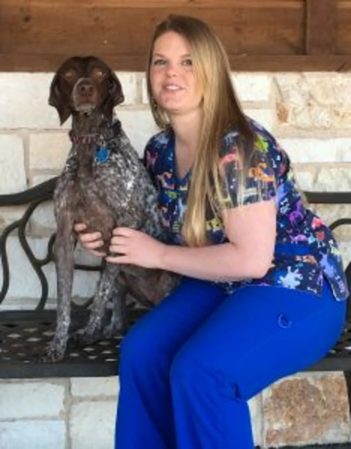 Amanda Armstrong holding a dog while sitting on a bench Amanda Armstrong holding a dog while sitting on a bench