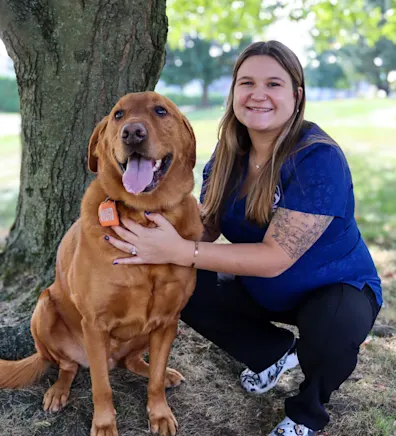 Kaitlin kneeling down and hugging her dog Ruger Kaitlin kneeling down and hugging her dog Ruger