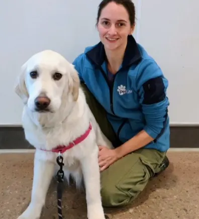 Jessica, trainer at PetSuites Braselton with a large white dog.
