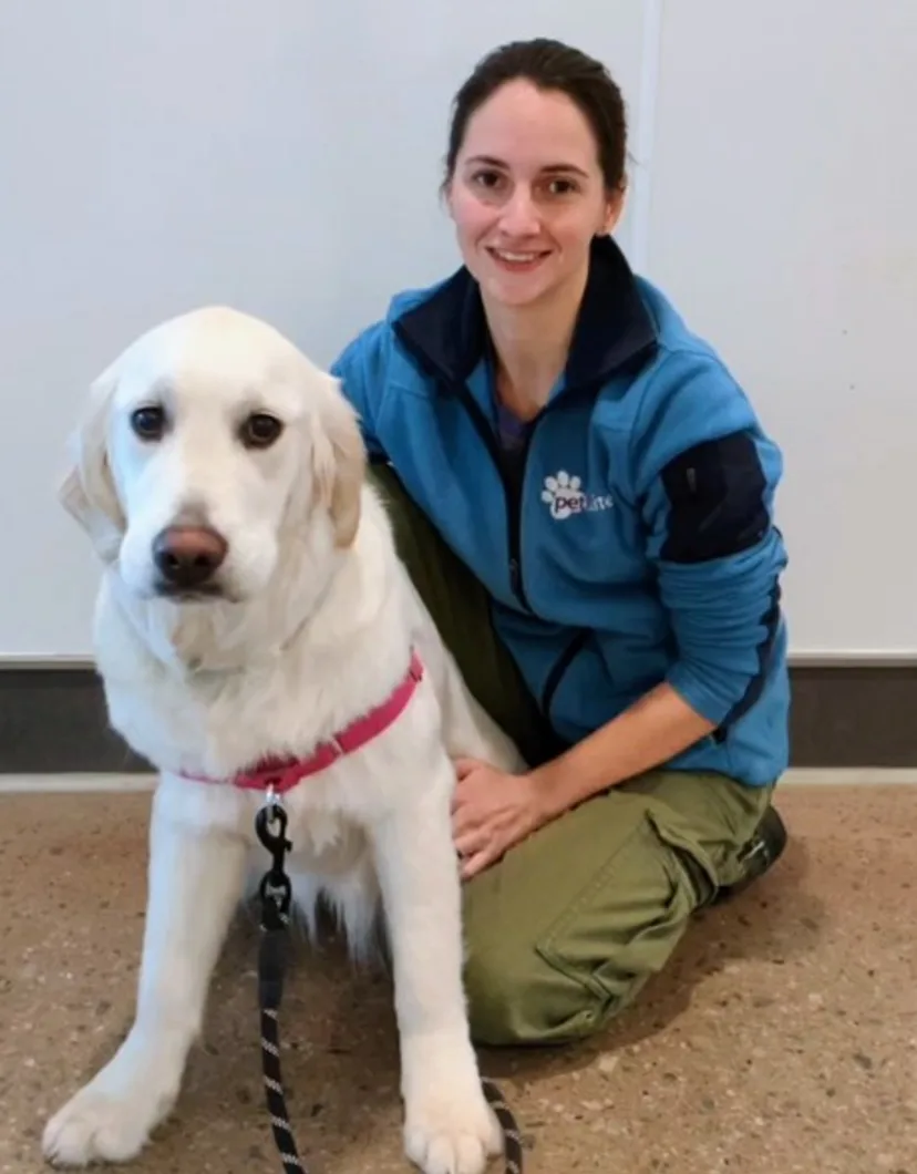 Jessica, trainer at PetSuites Braselton with a large white dog.