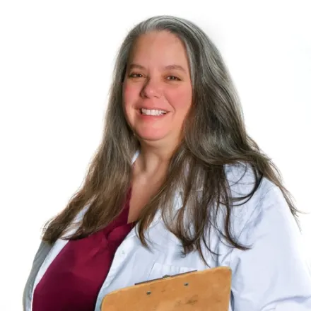 Dr. Sarah Neaderhouser posing with a clipboard