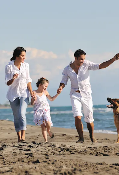 Dog with family running on the beach. Dog with family running on the beach.