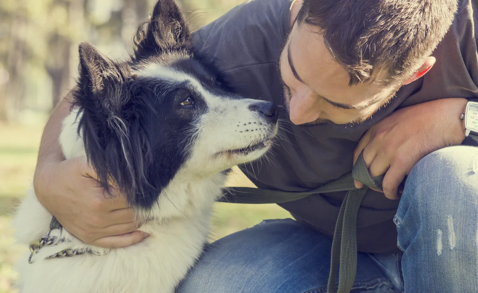 Dog with a man bending down giving him a kiss