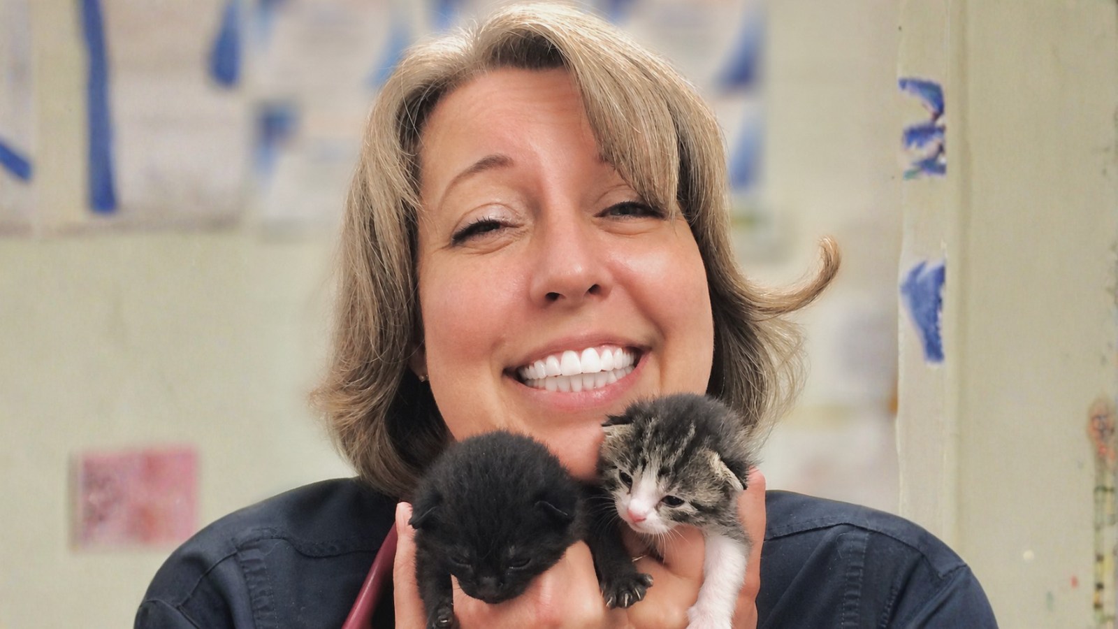 Dr. Mitchell smiling while holding two kittens.