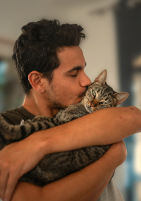 A person snuggling a cat