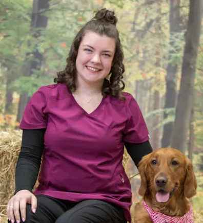 Jessica sitting with a Golden Retriever wearing a pink bandana